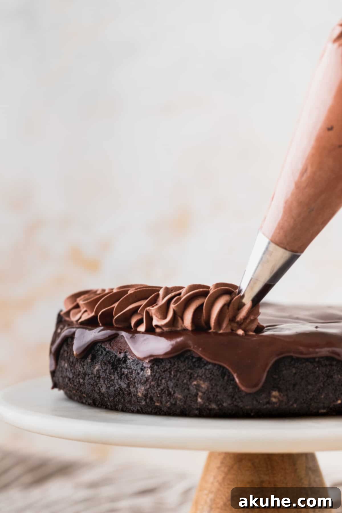 Decadent Triple Chocolate Cheesecake 9 Piping elegant swirls of chocolate whipped cream on top of the ganache-covered cheesecake.