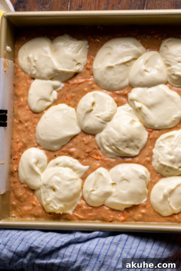 Spiced Carrot Coffee Cake 7 Cream cheese dollops evenly spread over carrot cake batter in a baking pan.