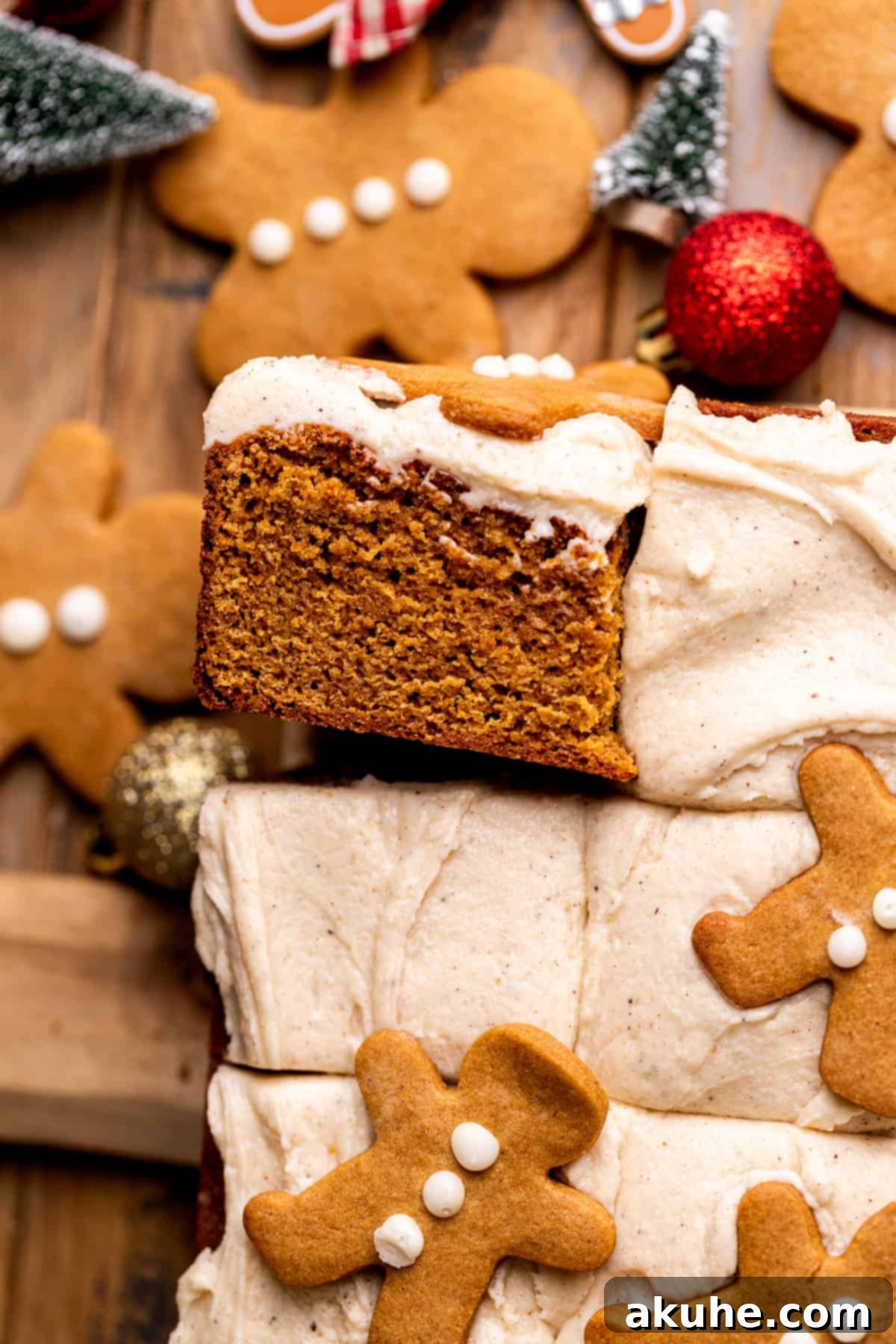 A perfectly portioned slice of moist gingerbread cake, showcasing the fluffy cinnamon cream cheese frosting and rich, spiced cake layers.