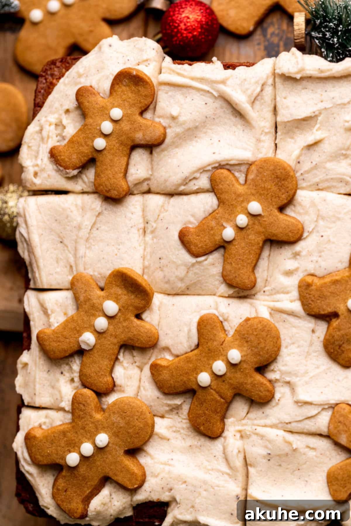 Top view of the finished gingerbread cake, generously covered with cinnamon cream cheese frosting and decorated with small gingerbread men cookies.