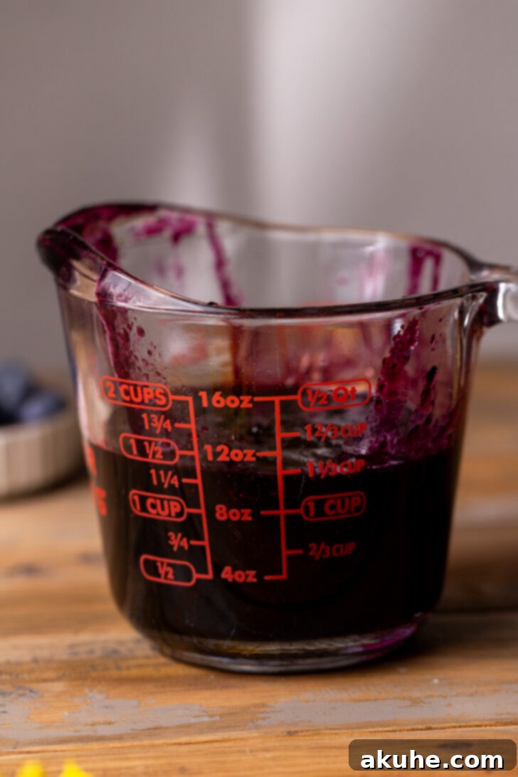 Easy Three Ingredient Blueberry Jam 7 Cooked blueberry jam being measured in a wet measuring cup, indicating it's just under 1 1/2 cups.