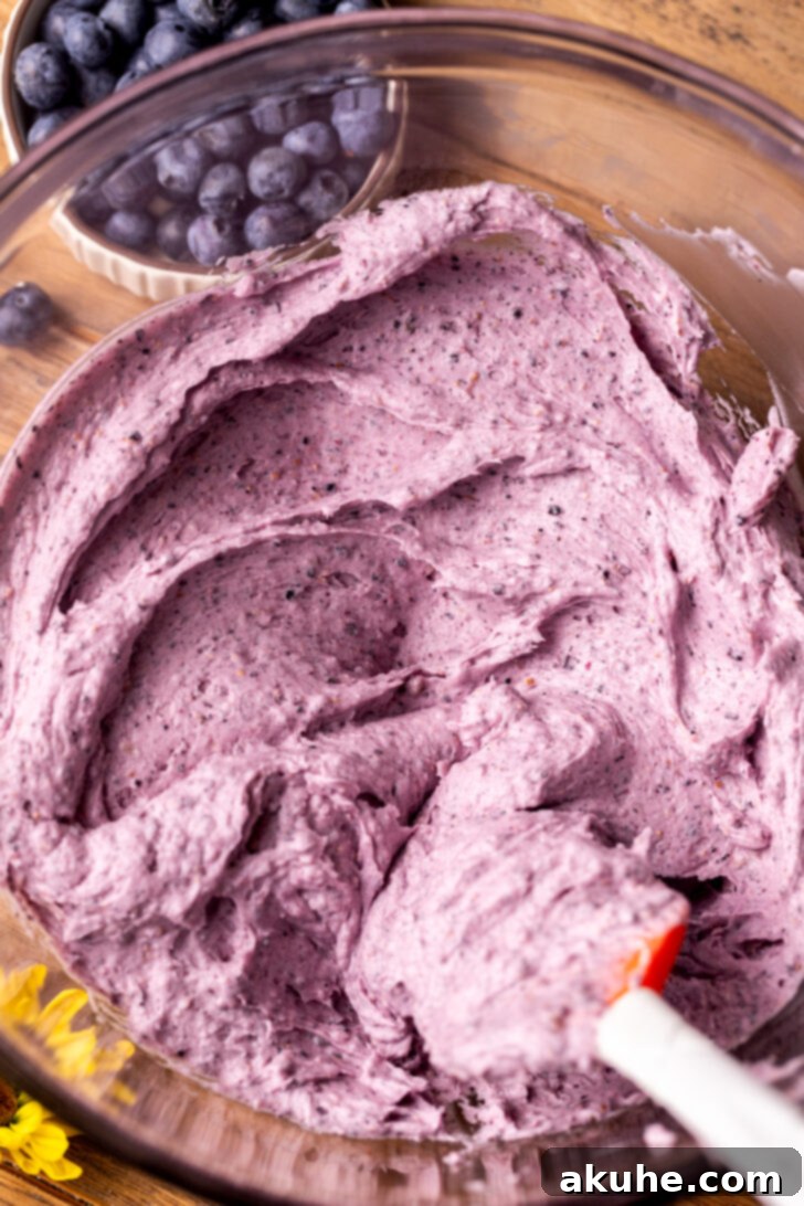 Velvety Blueberry Buttercream 2 A beautifully swirled glass bowl of homemade blueberry frosting, ready to be spread.