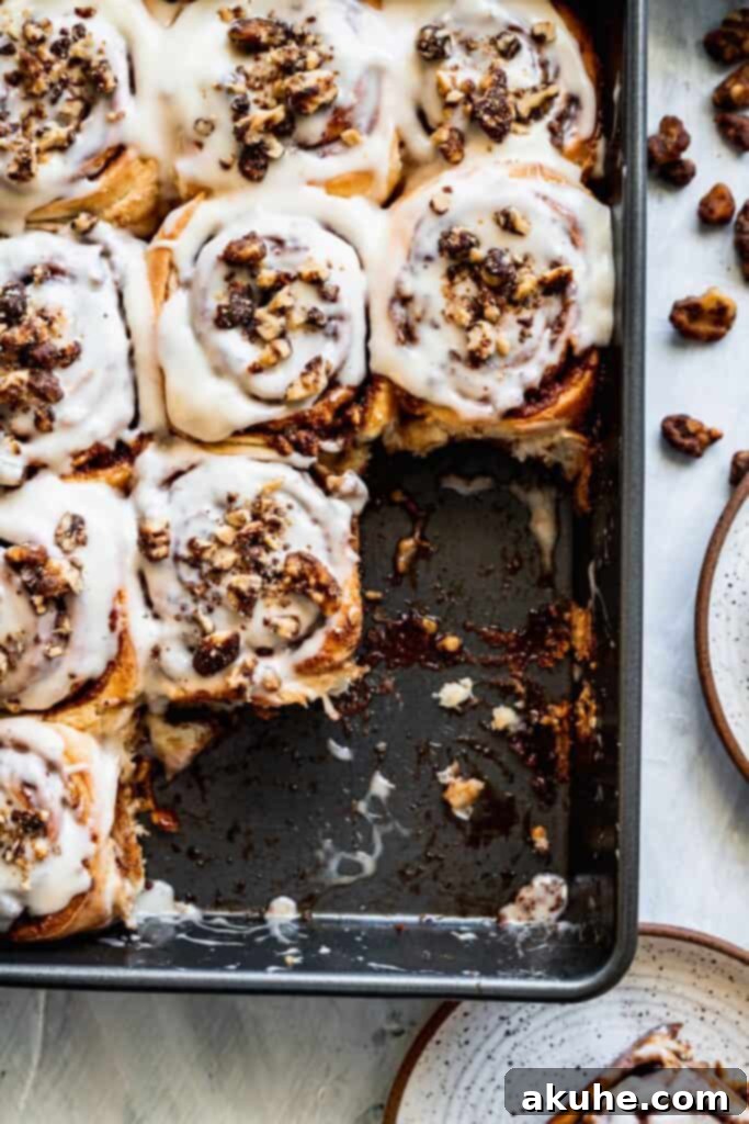 Nutty Cinnamon Swirls 11 Gooey walnut cinnamon rolls in a baking pan, with a few already enjoyed.