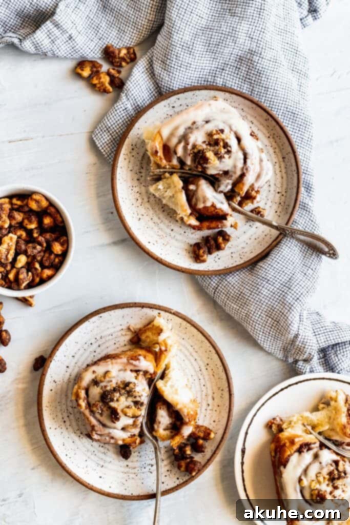 Nutty Cinnamon Swirls 12 Gooey cinnamon rolls served on plates with forks, ready to be eaten.