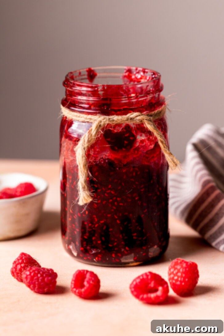 Effortless Raspberry Preserve 3 A glass jar filled with luscious homemade raspberry jam, ready for enjoyment.