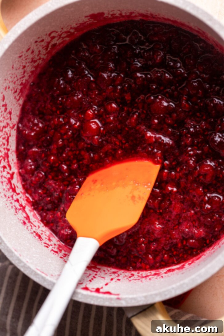 Effortless Raspberry Preserve 5 Raspberry juice bubbling in a pot, indicating the start of the cooking process for jam.