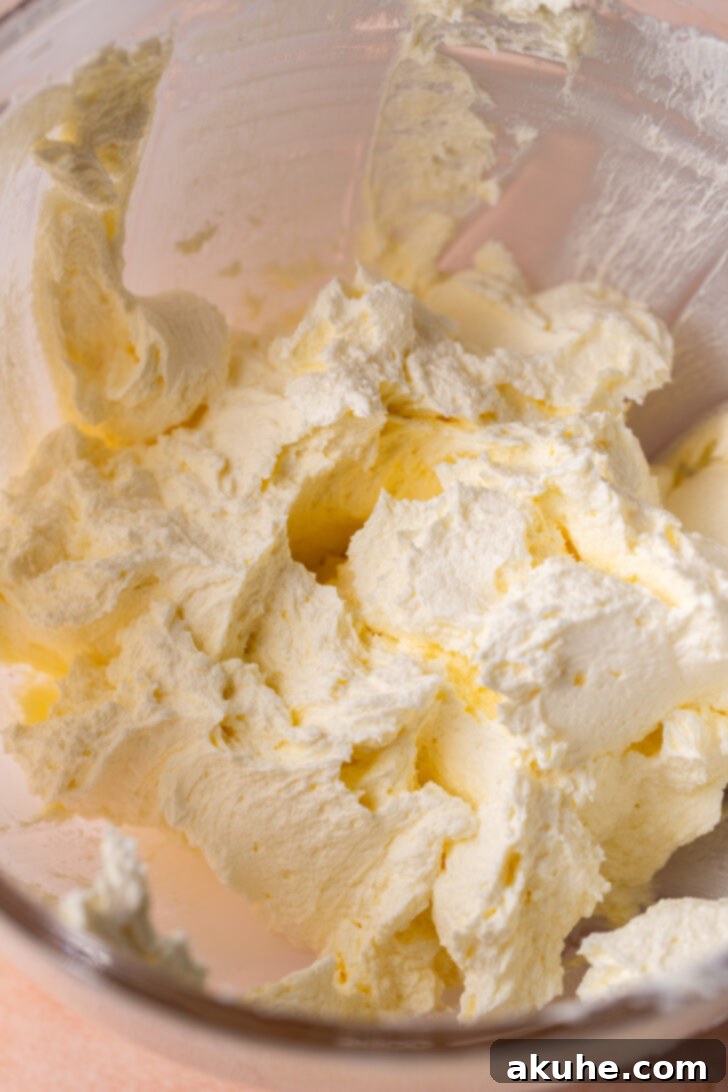 Softened butter and cream cheese in a mixing bowl, perfectly blended and creamy, ready for the next step.