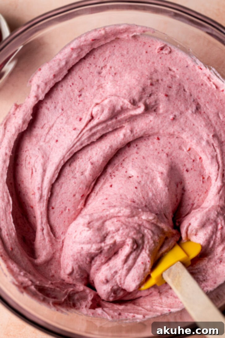 A bowl of freshly made raspberry cream cheese frosting, smooth and ready for piping or spreading onto desserts.