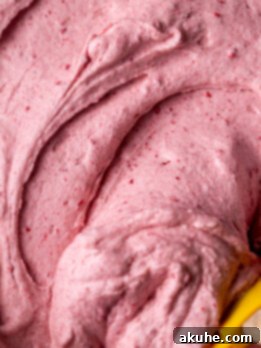 A close-up of The Best Raspberry Cream Cheese Frosting, smooth and ready to be used on desserts.