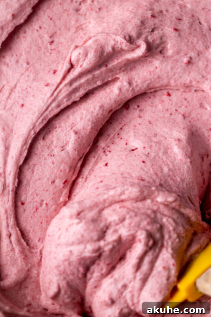 Fluffy raspberry cream cheese frosting in a mixing bowl.