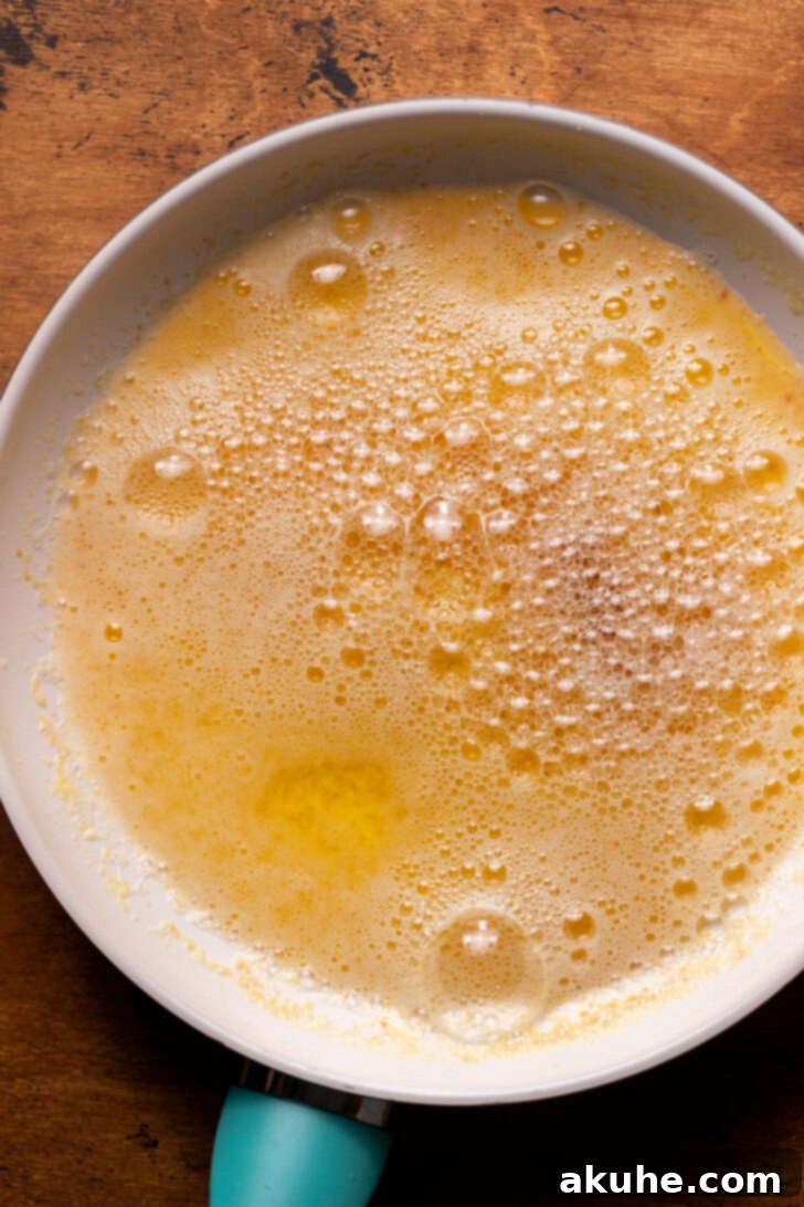 Achieving Golden Brown Butter 6 Foamy butter in a frying pan, with visible amber specks at the bottom.
