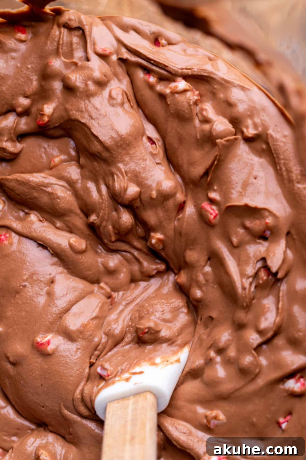 Peppermint Bark Cheesecake 6 Rich chocolate cheesecake batter, ready for baking, in a clear glass mixing bowl.