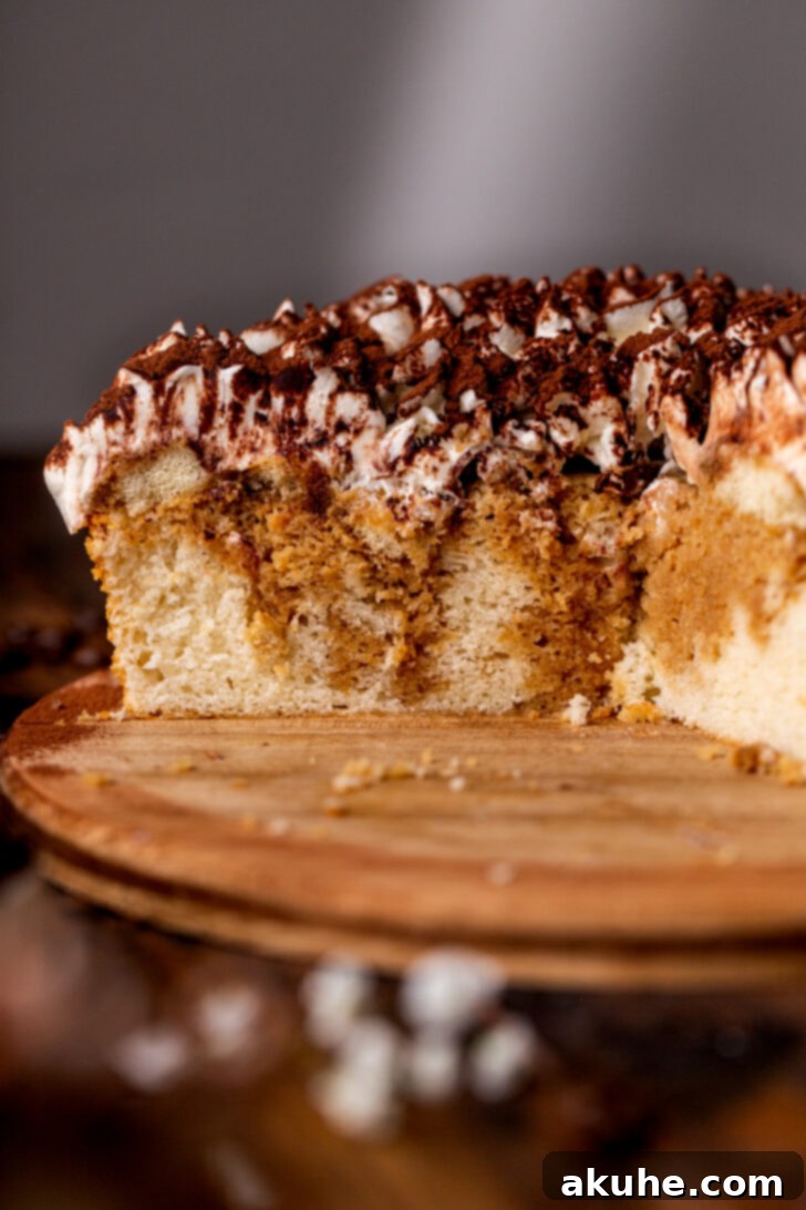 Tiramisu cake split in half, revealing the soaked cake and ladyfinger layers.