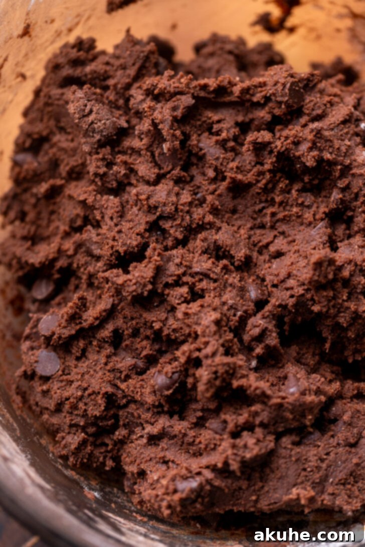 Cookie Dough Stuffed Cookies 5 Thick, dark chocolate cookie dough in a mixing bowl after all ingredients have been combined.