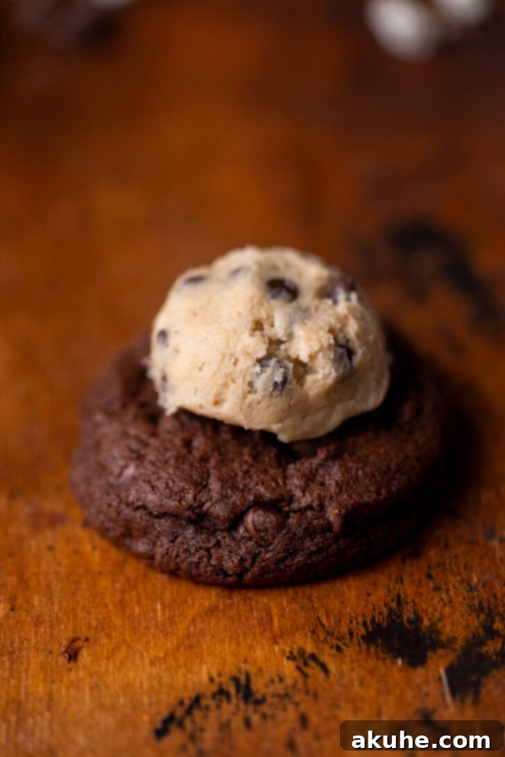 Cookie Dough Stuffed Cookies 9 A ball of edible cookie dough placed on top of a baked chocolate cookie, ready to be spread.