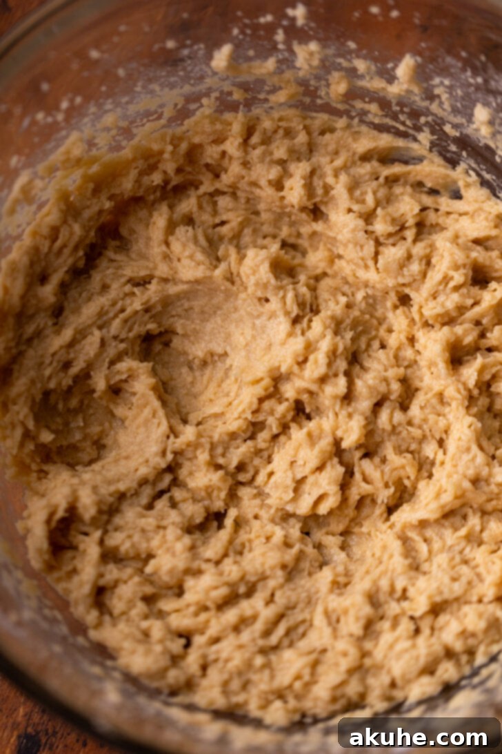 The Everything Cookie 4 Fluffy, pale yellow wet ingredients (butter and sugar) in a mixing bowl, indicating proper creaming.