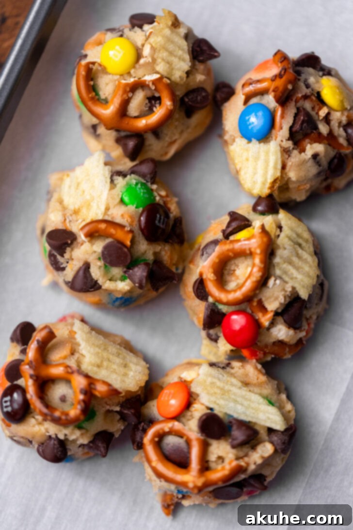 The Everything Cookie 7 Six evenly spaced cookie dough balls on a parchment-lined cookie sheet, ready for baking.