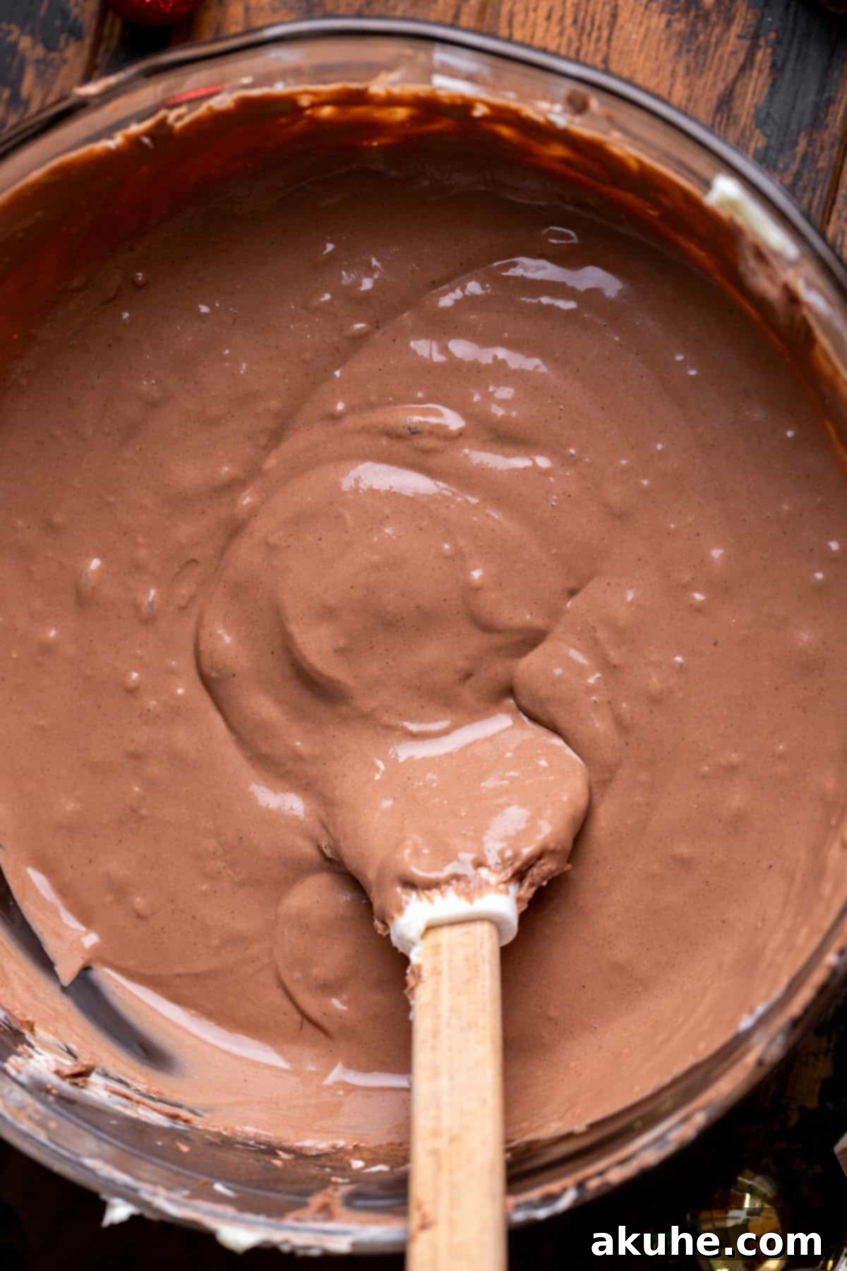 Decadent Hot Chocolate Cheesecake 5 Smooth and rich chocolate cheesecake batter in a clear glass bowl, showcasing its readiness.