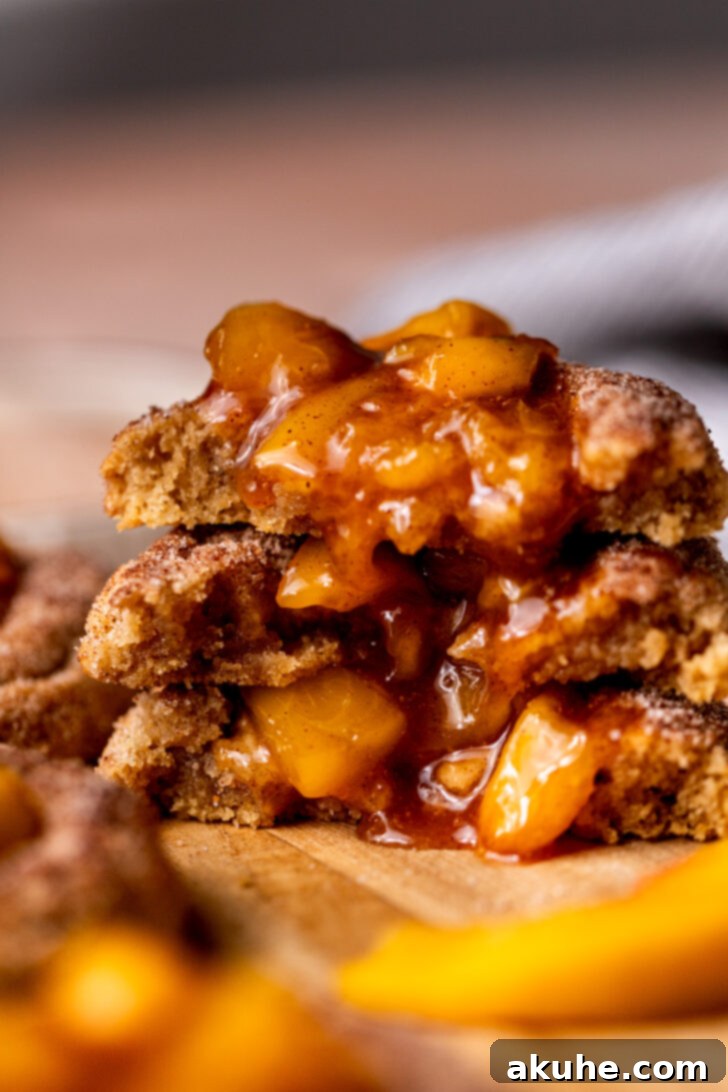 Delectable Peach Cobbler Cookies 11 A stack of three peach cobbler cookies, each split in half to reveal the rich, fruity filling.