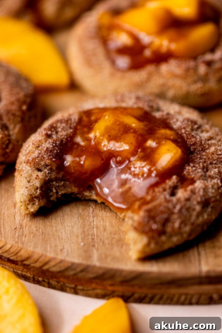 Delectable Peach Cobbler Cookies 3 A peach cobbler cookie with a bite missing, revealing the soft interior and generous peach filling.