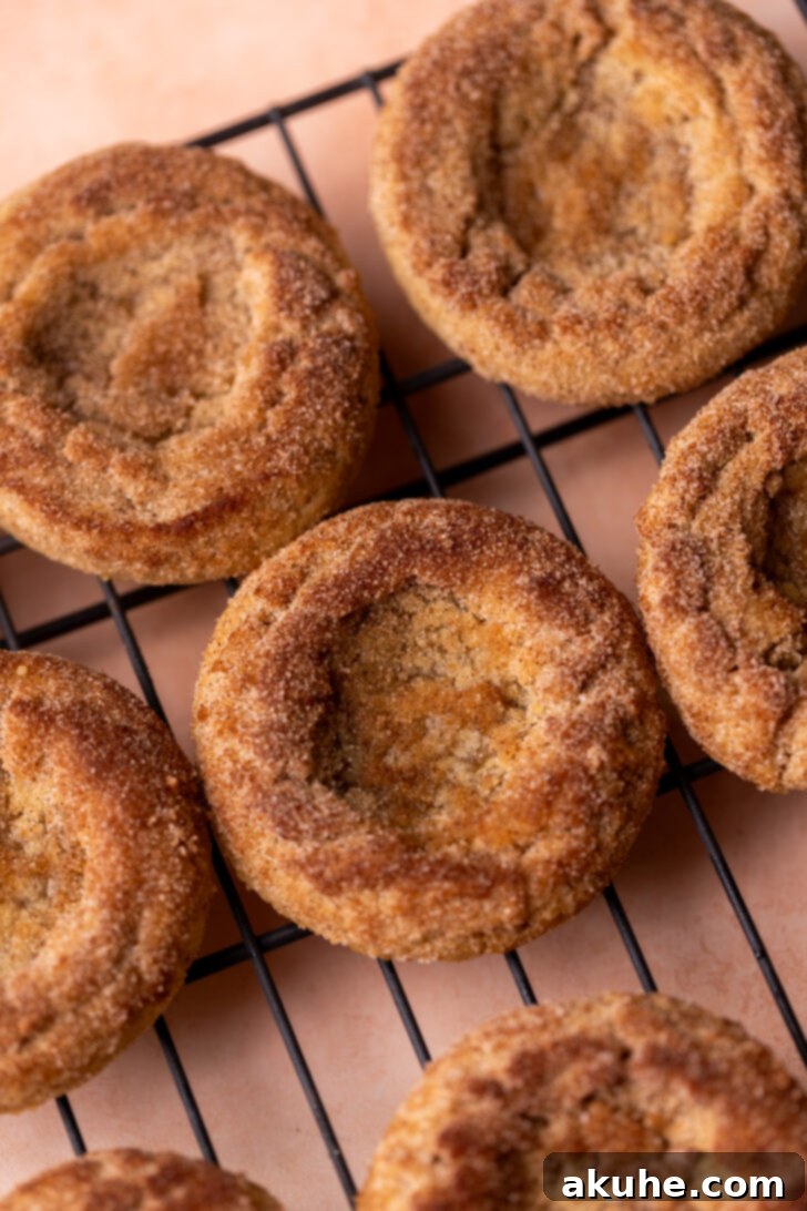Delectable Peach Cobbler Cookies 8 Warm cookies being brushed with melted butter and rolled in cinnamon sugar on a wire rack.