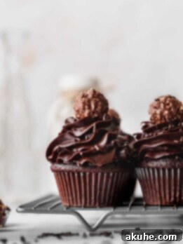 Decadent Chocolate Fudge Cupcakes 11 Delicious Chocolate Fudge Cupcakes on a wire rack, freshly baked and ready to be frosted.