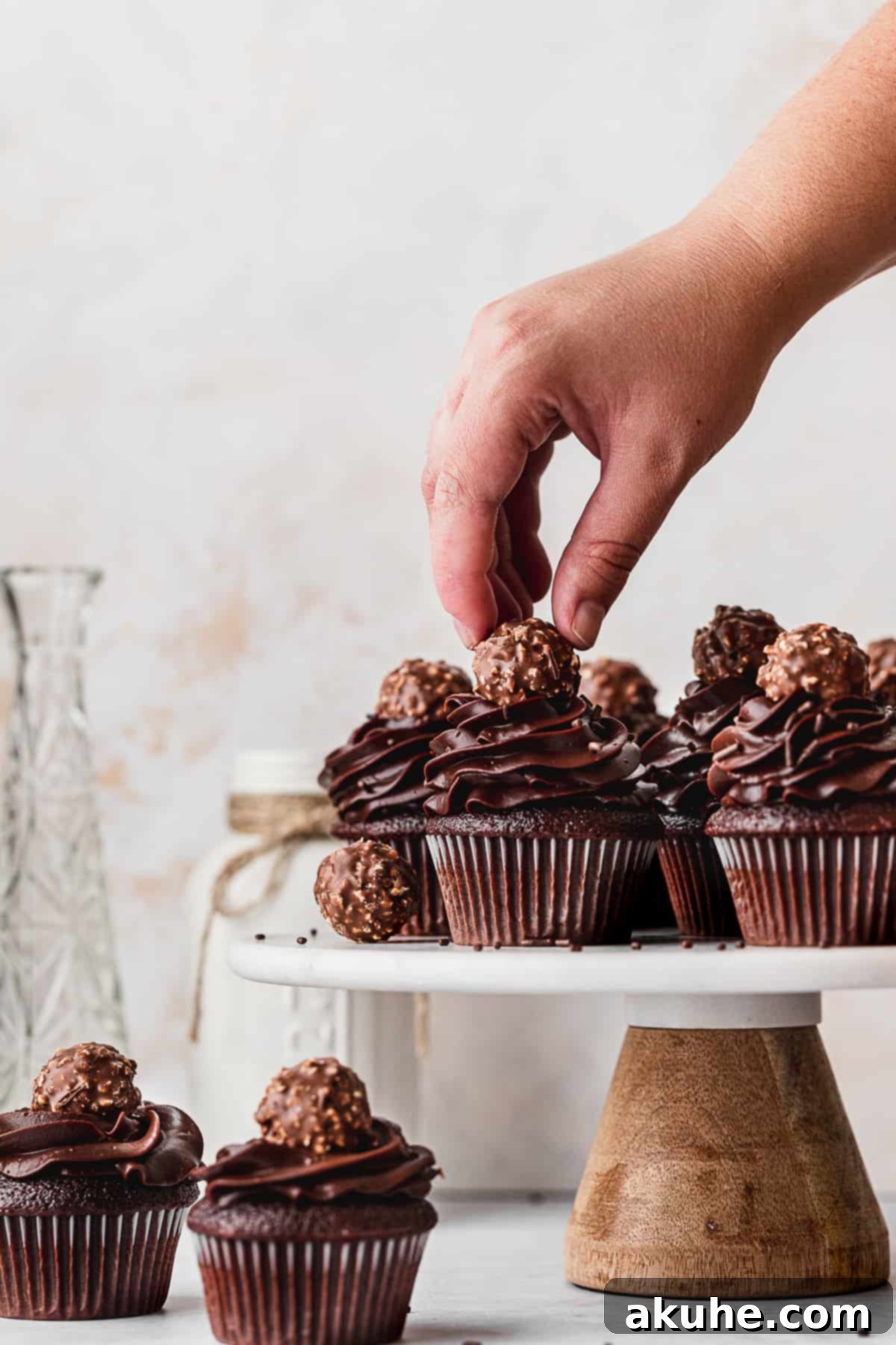 Decadent Chocolate Fudge Cupcakes 3 Decorating chocolate fudge cupcakes with rich ganache and delicate truffles, highlighting the dessert's elegant finish.