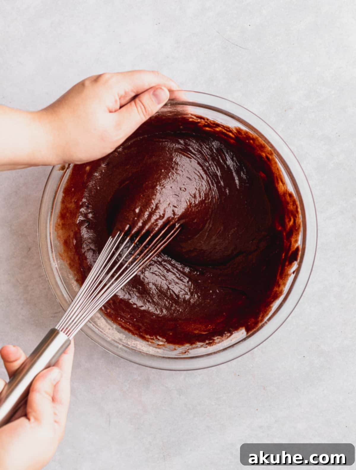 Decadent Chocolate Fudge Cupcakes 5 Mixing rich chocolate cupcake batter in a clear glass bowl, showcasing the smooth, dark consistency before baking.