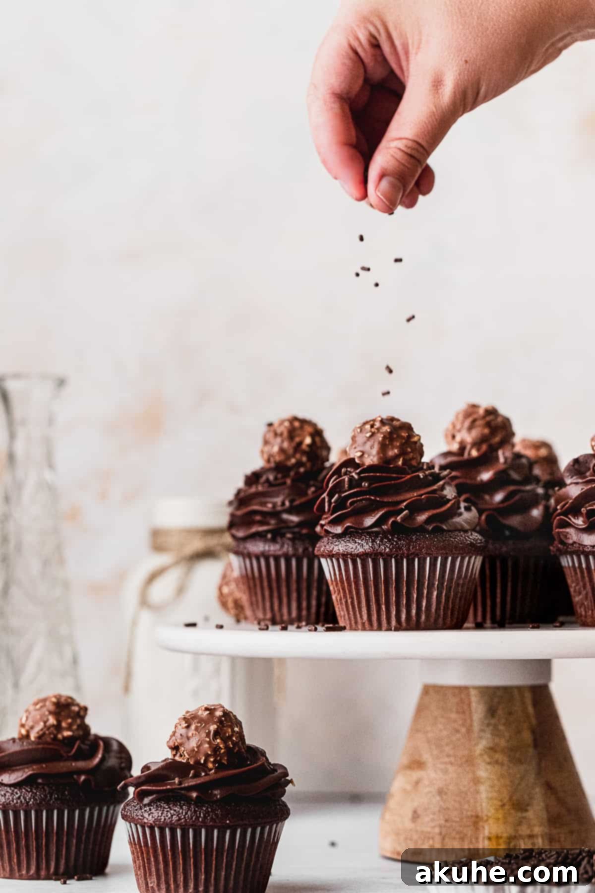 Decadent Chocolate Fudge Cupcakes 10 Finishing touch: sprinkling delicate chocolate sprinkles over frosted chocolate fudge cupcakes, enhancing their visual appeal.