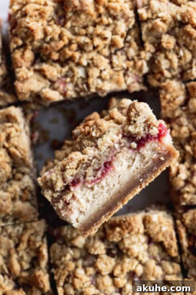 Nostalgic Peanut Butter and Jelly Cheesecake Bars 9 A close-up of a single peanut butter and jelly cheesecake bar, perfectly sliced and showcasing its layers, held up to the camera
