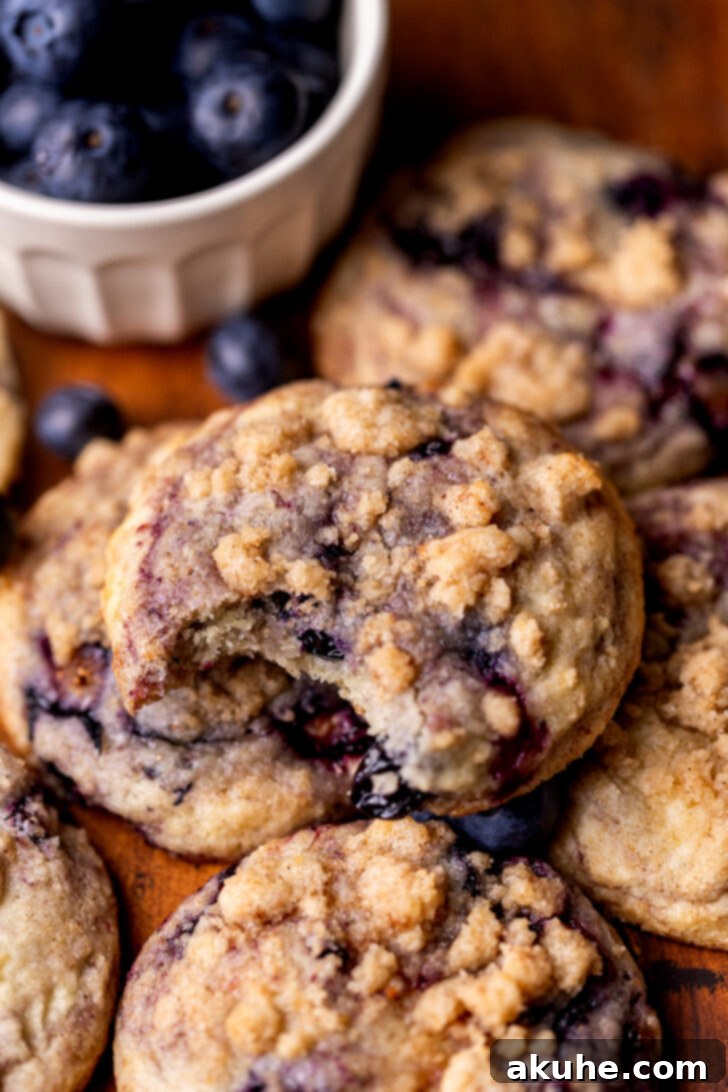 Blueberry Muffin Dream Cookies 7 A blueberry muffin cookie with a bite taken out, showing its fluffy interior and blueberries.