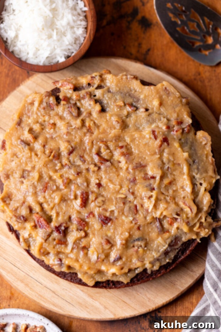 Decadent Chocolate Coconut Pecan Cake 9 Generous layer of coconut pecan frosting spread evenly over a chocolate cake layer, showing the beautiful texture.