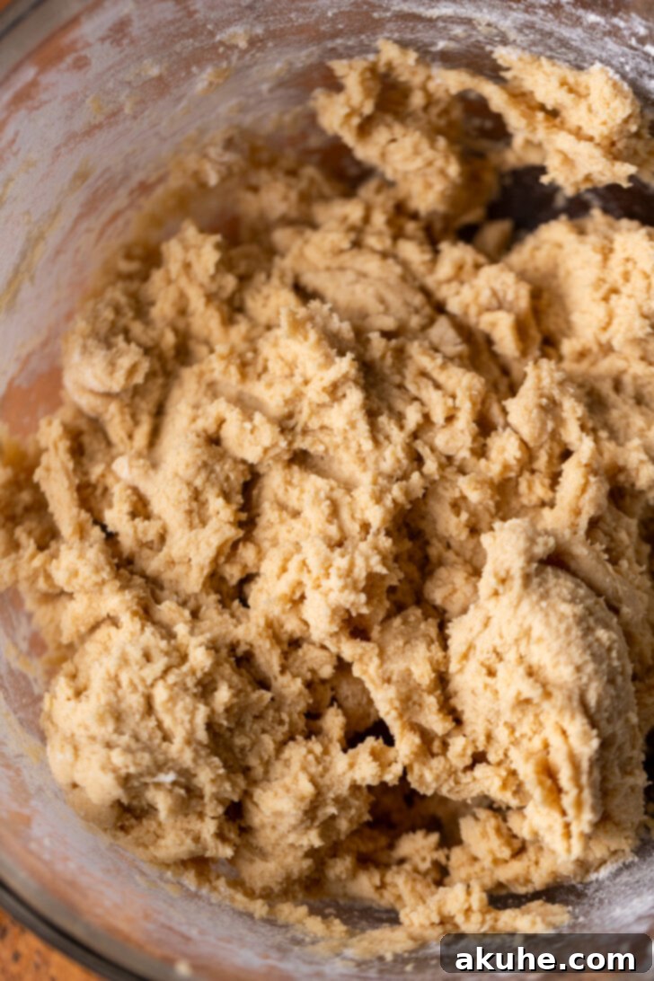 Golden-brown cookie dough resting in a mixing bowl.