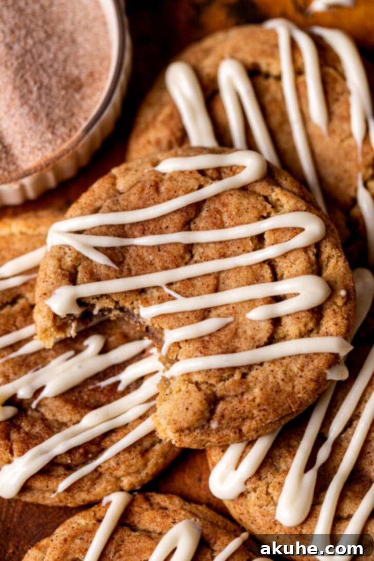 A freshly baked cinnamon roll cookie with a bite taken out, showing the soft interior.