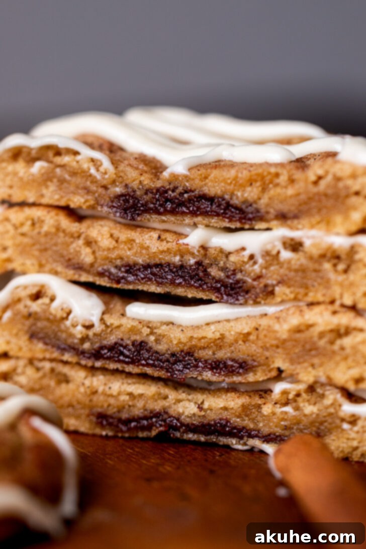 Close up detailed view of the rich, gooey cinnamon filling inside a baked cinnamon roll cookie.