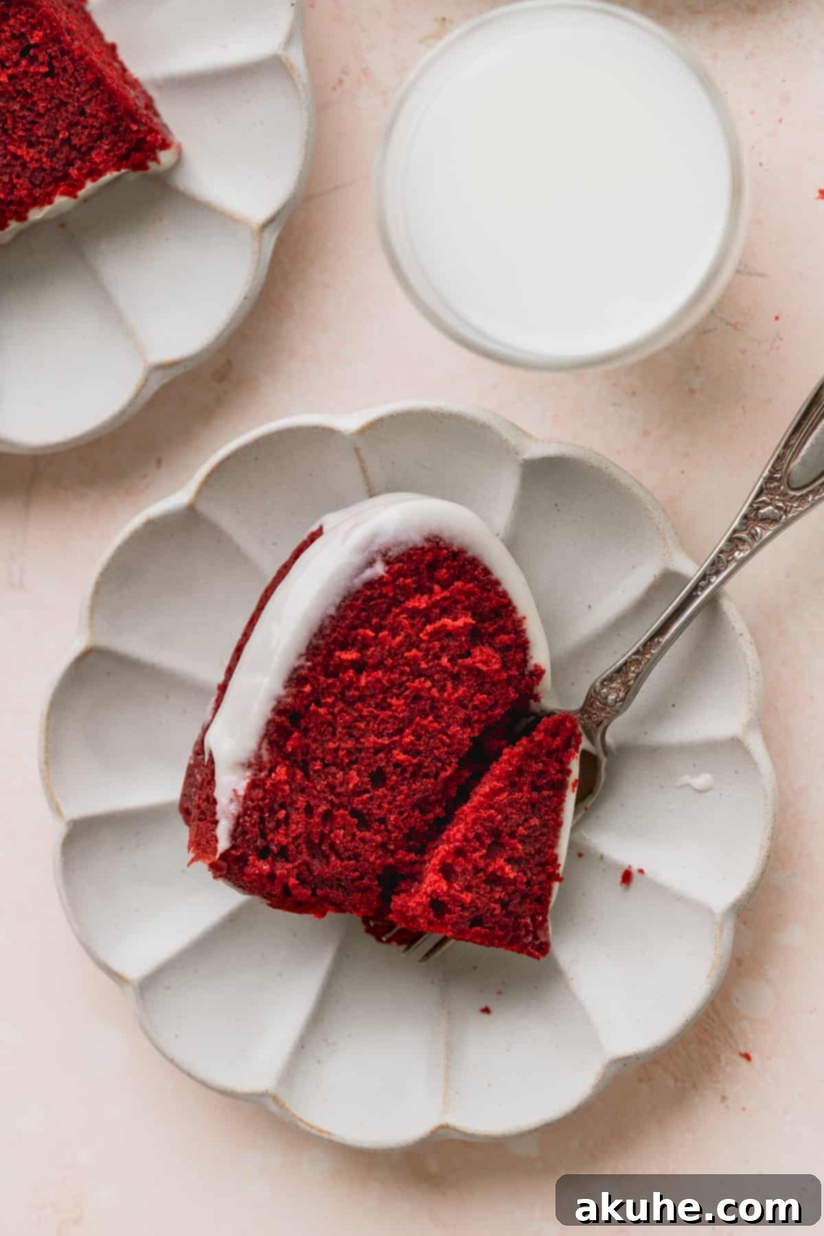 Crimson Crown Bundt Cake 8 A perfect slice of Red Velvet Bundt Cake on a white plate, showcasing its fluffy texture and rich glaze.