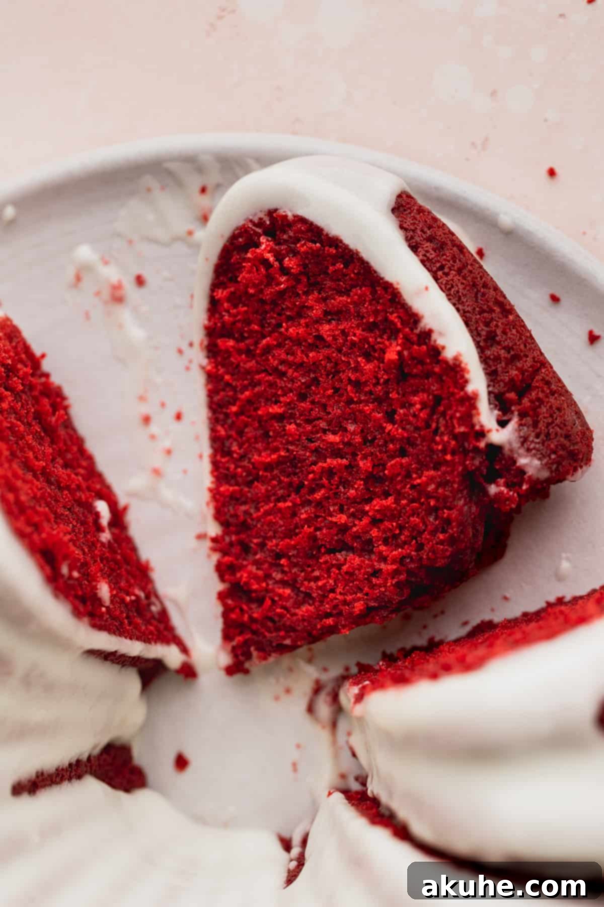 Crimson Crown Bundt Cake 9 A single, elegant slice of Red Velvet Bundt Cake on a white platter, inviting indulgence.