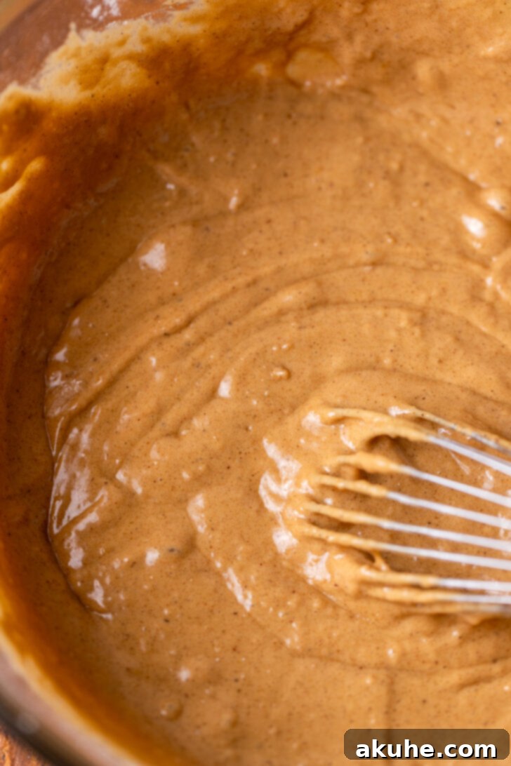 Harvest Apple Cider Donuts 5 Smooth donut batter, a light brown color, in a mixing bowl after dry ingredients have been folded in.