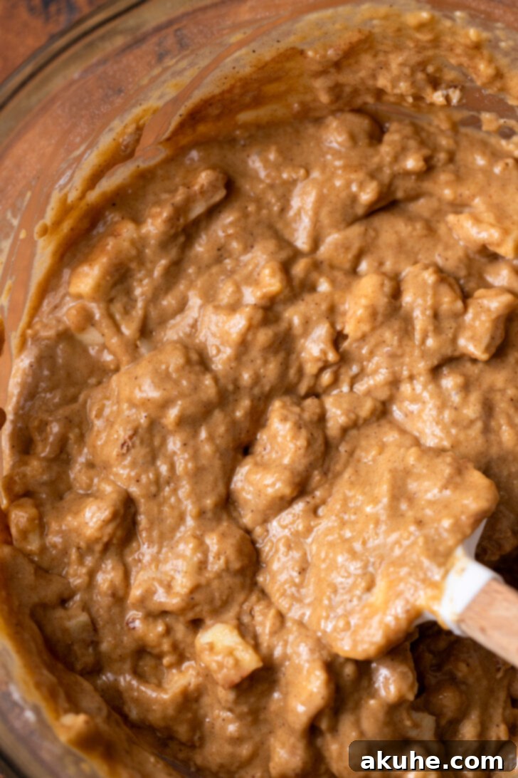 Golden Apple Muffins 6 Muffin batter resting in a mixing bowl, showcasing its thick, slightly lumpy consistency before being scooped into the pan.