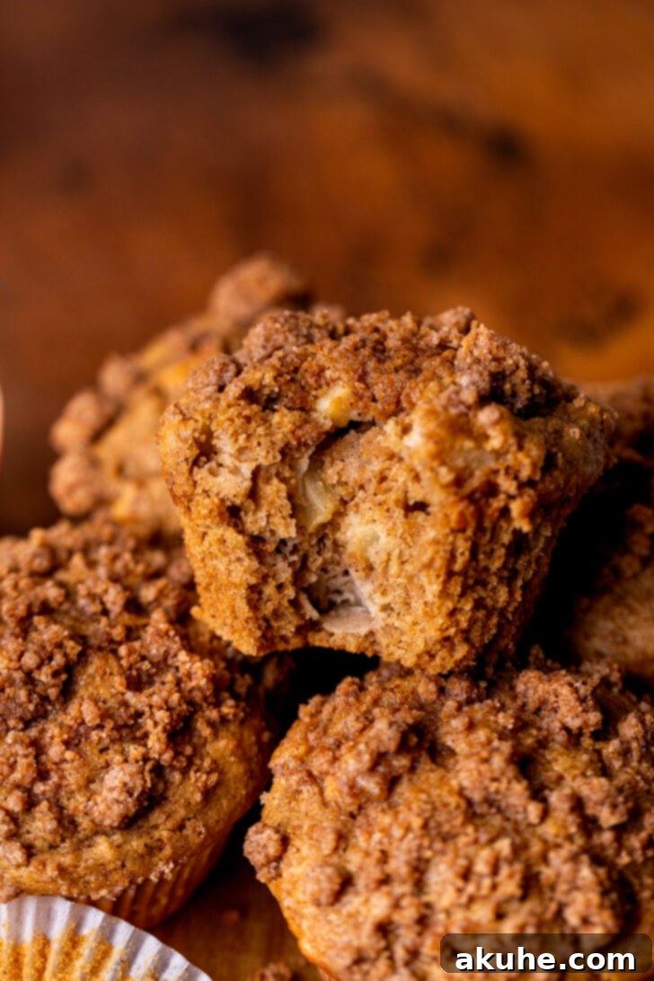 Golden Apple Muffins 9 A stack of golden-brown apple muffins with a generous streusel topping, perfectly baked and ready to be enjoyed.