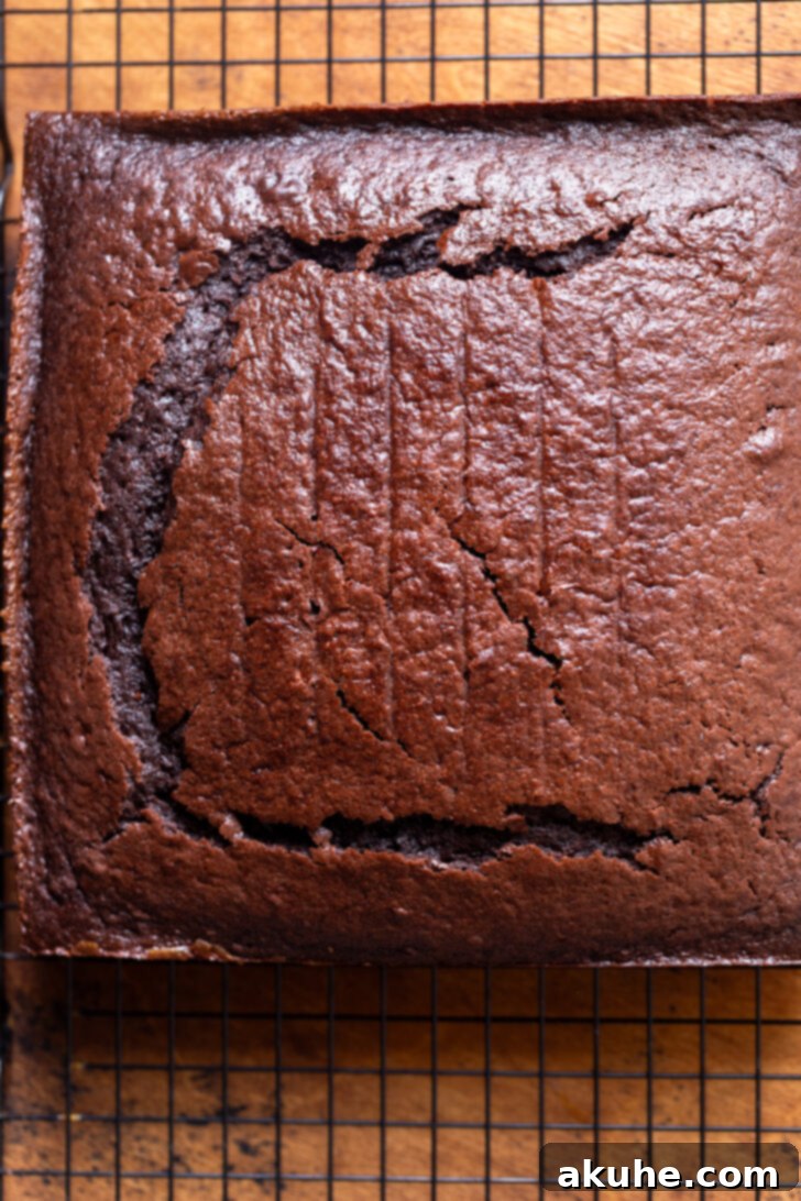 Decadent Chocolate Caramel Dream 5 Freshly baked chocolate cake resting on a wire rack after removal from the pan, ready for the domed top to be neatly trimmed.