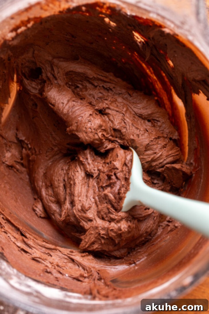 Decadent Chocolate Caramel Dream 6 Velvety smooth and thick chocolate cream cheese frosting in a white bowl, perfectly whipped and ready for spreading onto the cake.