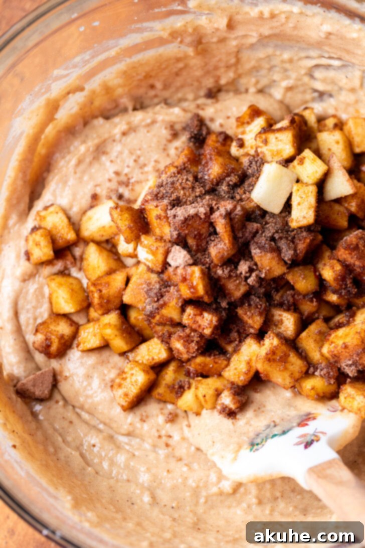 Spiced Apple Bread 5 The prepared cinnamon apples gently folded into the luscious apple bread batter in a mixing bowl.
