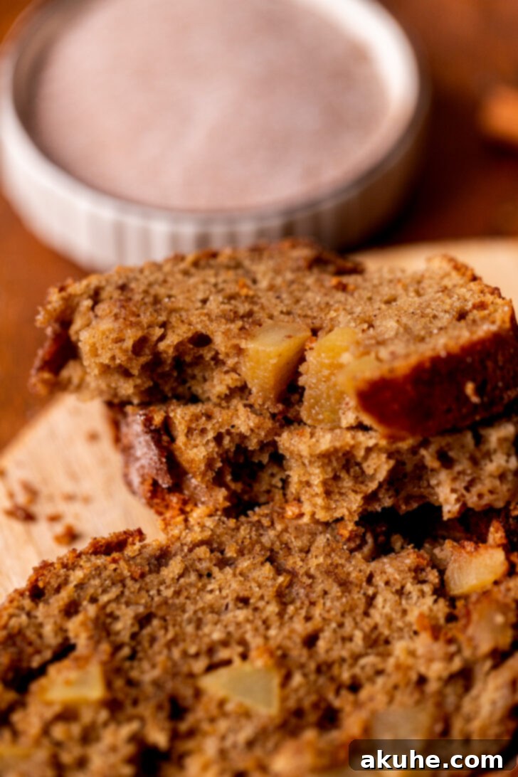 Spiced Apple Bread 8 A slice of apple bread cut in half, revealing the soft, moist interior and beautifully distributed apple pieces.