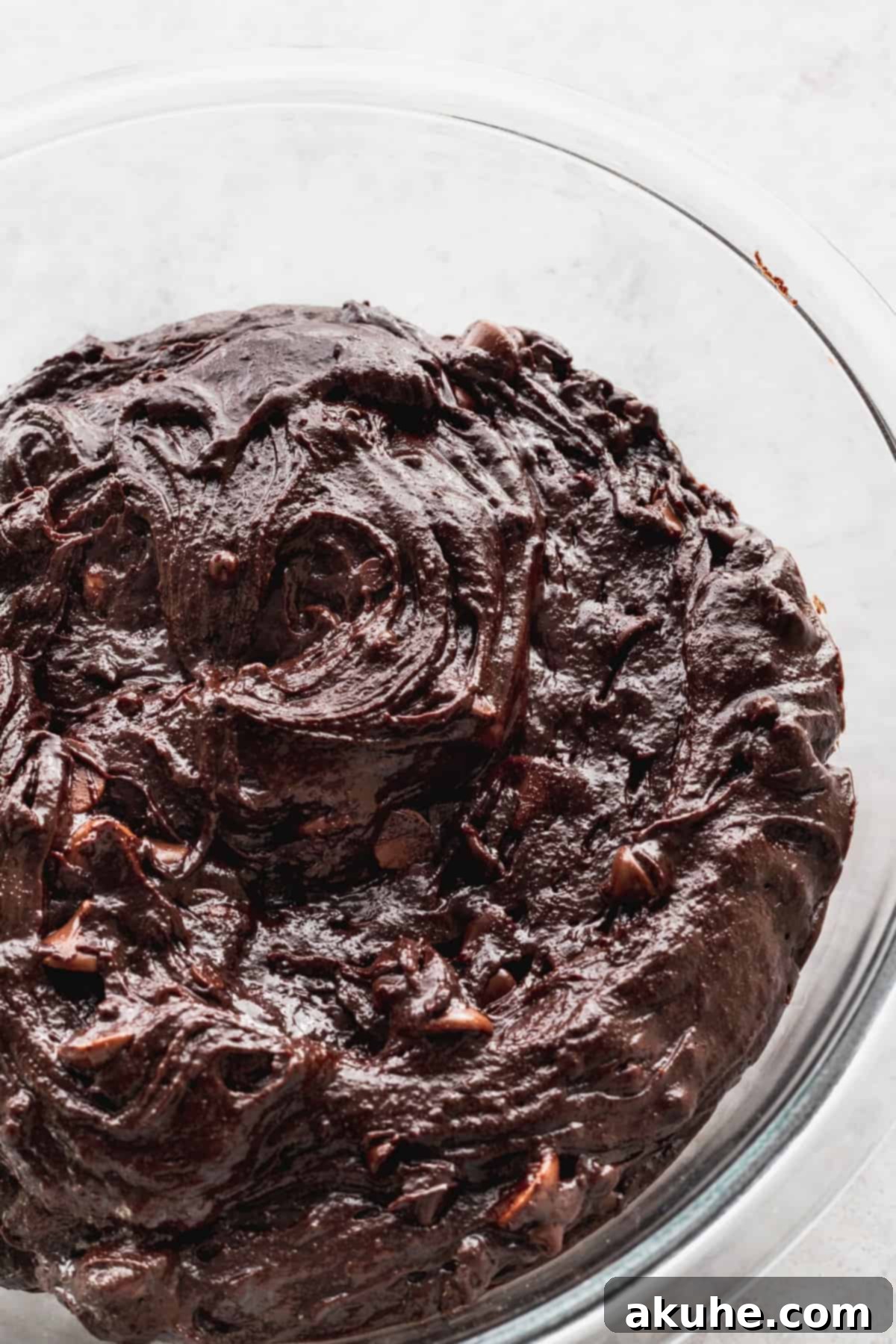 Thick, rich brownie batter in a large mixing bowl, showcasing its dense texture before baking.