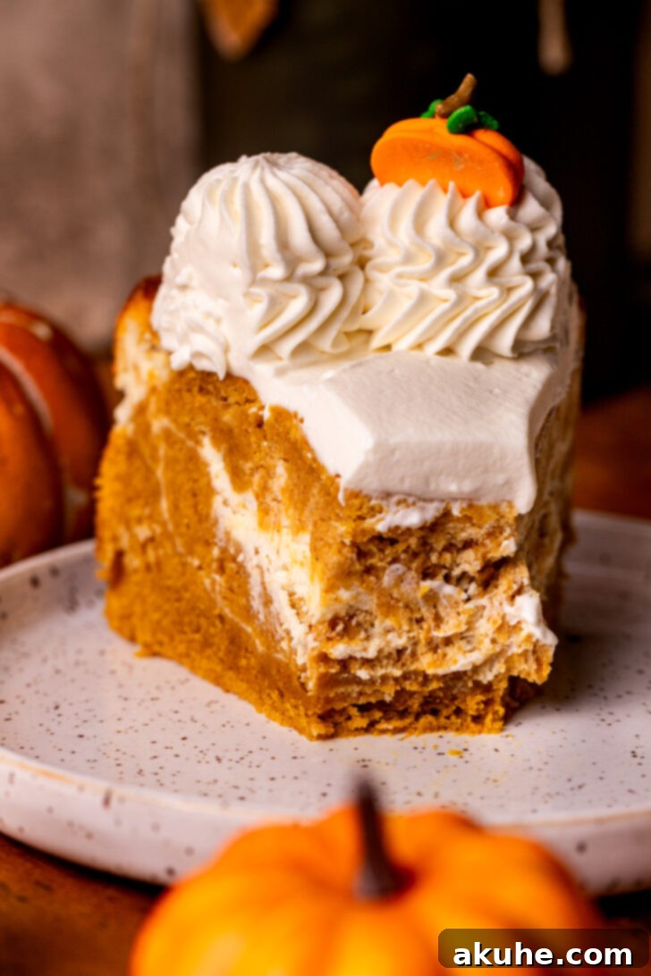 Autumn Pumpkin Cheesecake Cake 11 Pumpkin cheesecake cake on a plate with a bite missing, ready to be enjoyed.