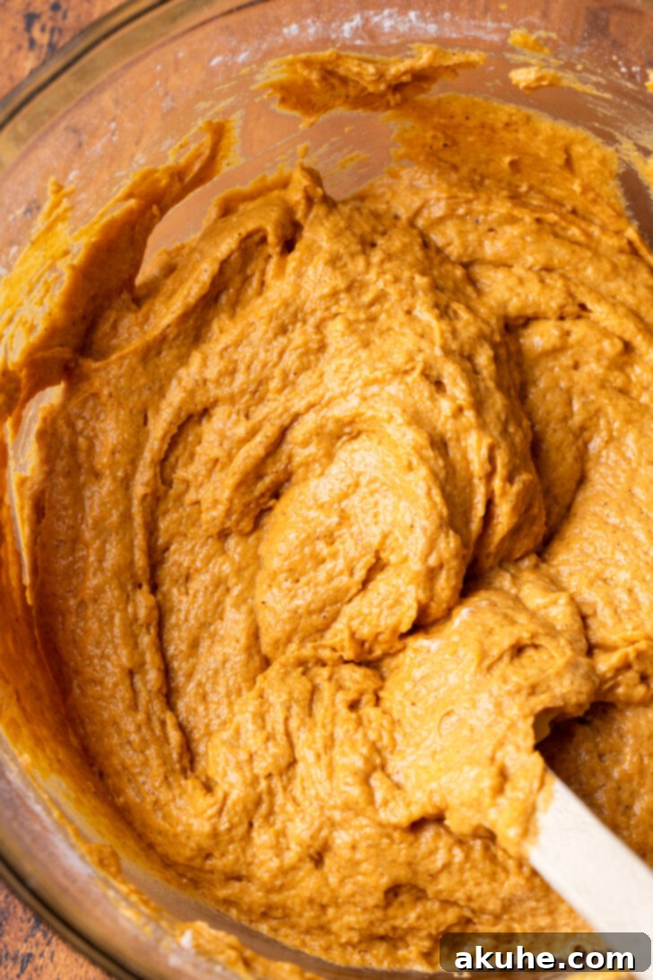 Autumn Pumpkin Cheesecake Cake 4 Pumpkin cake batter in a bowl, showing its bright orange color.