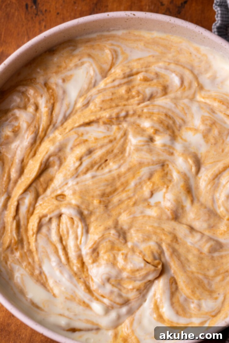 Autumn Pumpkin Cheesecake Cake 7 Pumpkin and cheesecake batter swirled together in a springform pan before baking.