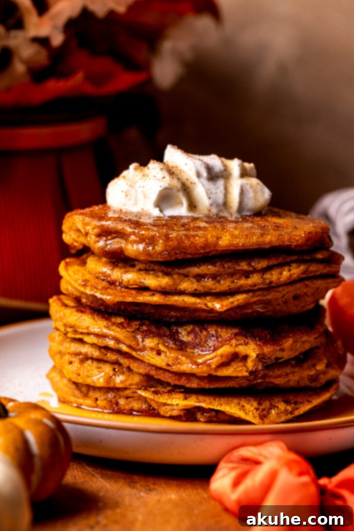 Warm Spiced Pumpkin Pancakes 3 A delectable stack of pumpkin pancakes, perfectly golden and inviting, ready to be enjoyed.