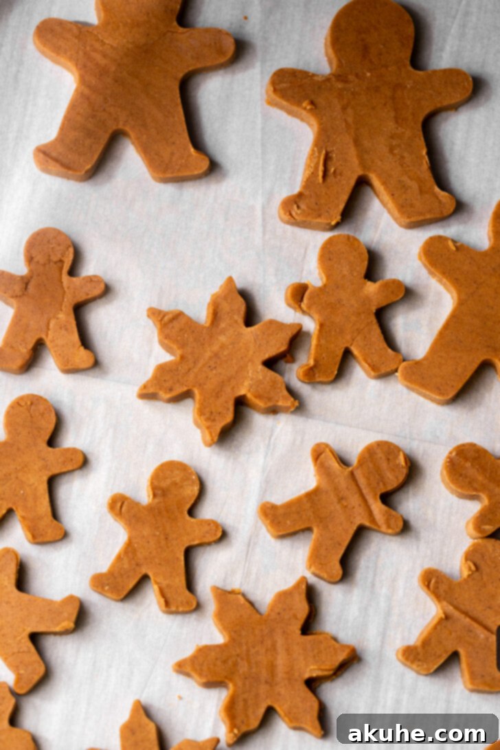 Irresistibly Soft Gingerbread 7 Gingerbread men cut out from chilled dough, neatly arranged on parchment paper.